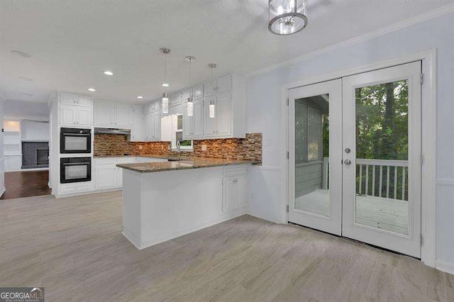 9415 Martin Rd, Roswell, GA 30076 - kitchen featuring french doors, under cabinet range hood, white cabinetry, a peninsula, and backsplash