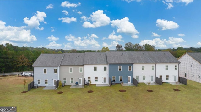 rear view of property with fence, a lawn, an outdoor fire pit, and a patio area