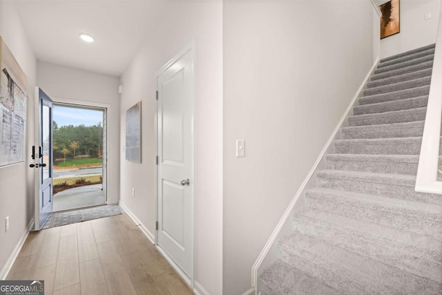 foyer entrance featuring recessed lighting, baseboards, stairs, and wood finished floors