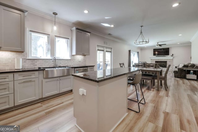 3065 Meadow Springs Dr, Watkinsville, GA 30677 - kitchen with ornamental molding, open floor plan, a center island, a kitchen bar, and light wood-style flooring