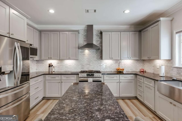 3065 Meadow Springs Dr, Watkinsville, GA 30677 - kitchen featuring stainless steel appliances, wall chimney exhaust hood, ornamental molding, light wood finished floors, and tasteful backsplash