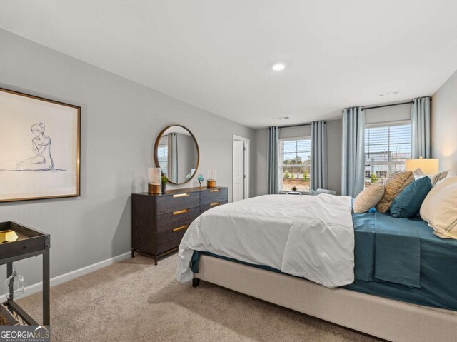 bedroom featuring baseboards and light colored carpet