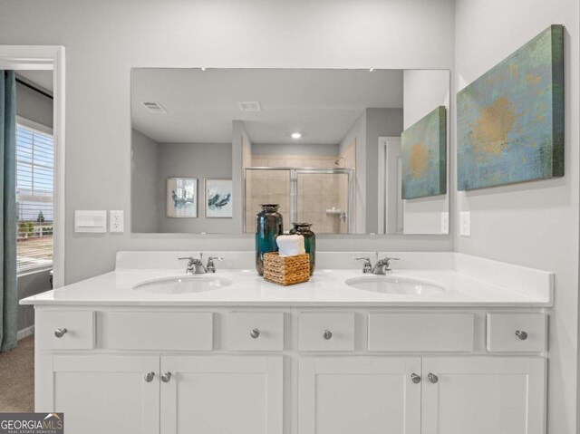 full bath with double vanity, visible vents, a sink, and a stall shower
