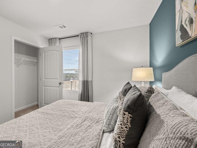 carpeted bedroom featuring baseboards, visible vents, and a closet