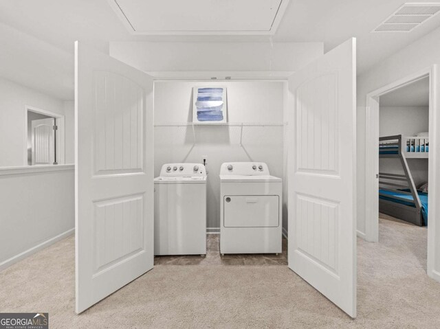 clothes washing area with attic access, separate washer and dryer, visible vents, and laundry area