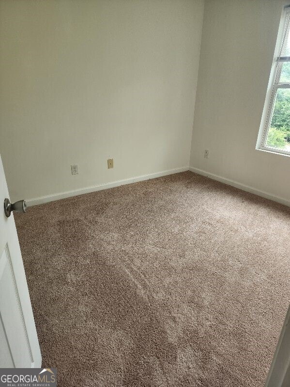 carpeted spare room with baseboards