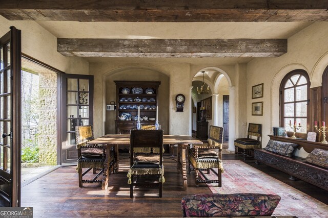 2100 W Wesley Rd, Atlanta, GA 30327 - dining area with beam ceiling, wood-type flooring, decorative columns, a textured wall, and arched walkways