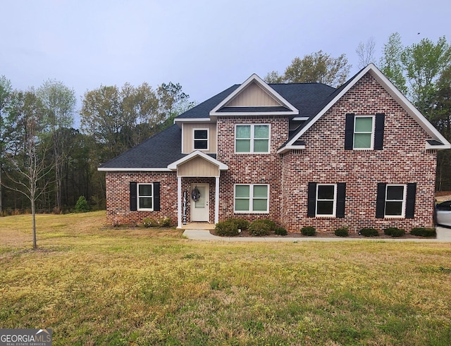 craftsman inspired home with brick siding, a front yard, and roof with shingles