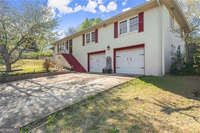 view of front facade featuring a front yard, stucco siding, stairs, an attached garage, and driveway