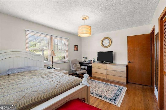 bedroom featuring a textured ceiling and wood finished floors