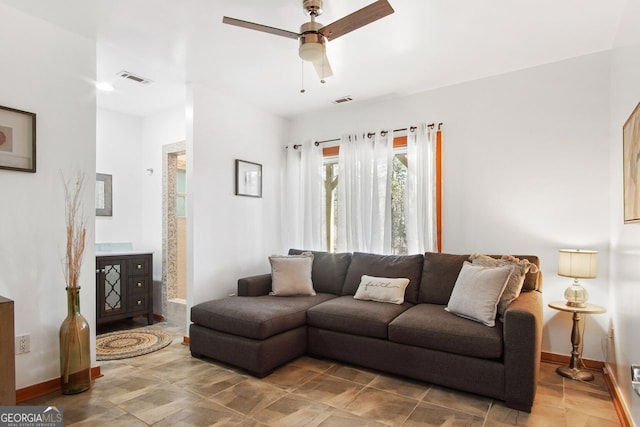 living area featuring baseboards, a ceiling fan, and visible vents