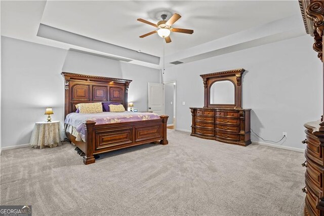 bedroom with a raised ceiling, carpet, and baseboards