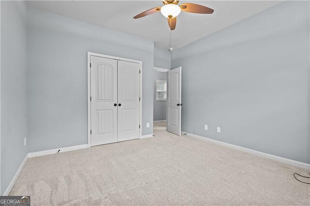 unfurnished bedroom with a ceiling fan, carpet, a closet, and baseboards