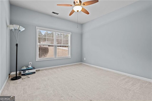 carpeted empty room featuring baseboards, visible vents, and ceiling fan