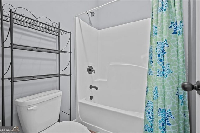 full bath featuring toilet and shower / bath combo with shower curtain