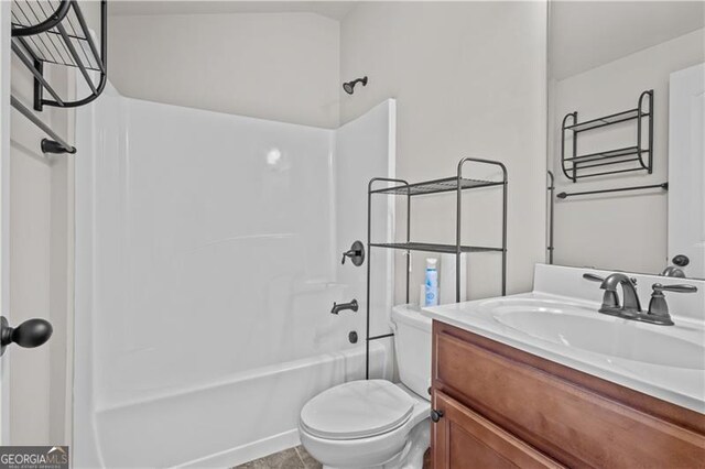 bathroom featuring shower / washtub combination, toilet, and vanity