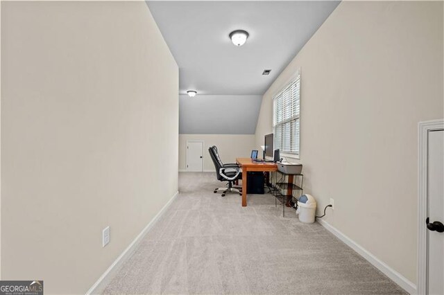 office with baseboards, carpet floors, lofted ceiling, and visible vents