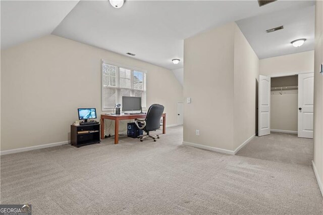 carpeted office space featuring baseboards, lofted ceiling, and visible vents