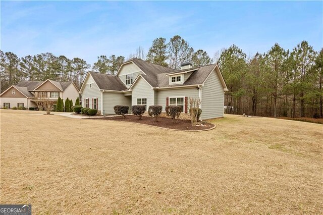 rear view of house featuring a lawn