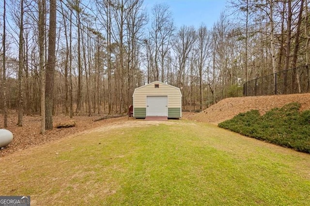 view of yard featuring a storage unit, driveway, an outdoor structure, and a garage