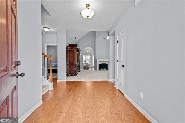 foyer entrance with baseboards, stairs, and light wood-type flooring