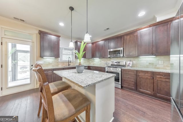 64 Durana Way, Dallas, GA 30132 - kitchen featuring stainless steel appliances, a center island, ornamental molding, dark wood-type flooring, and hanging light fixtures