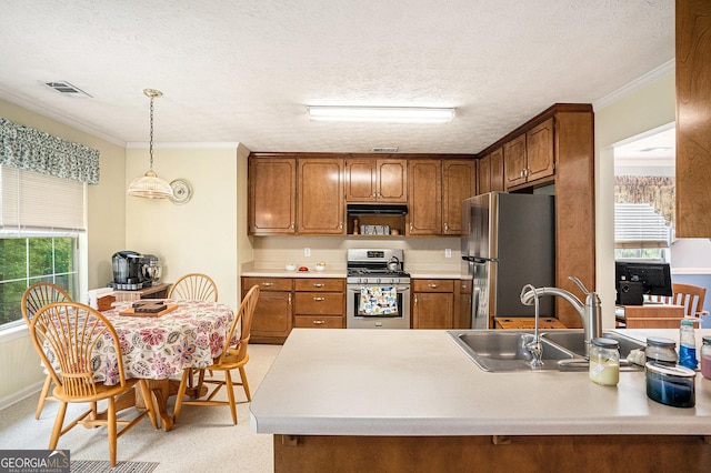kitchen featuring visible vents, brown cabinetry, crown molding, a sink, and stainless steel appliances