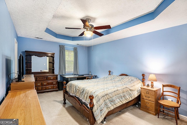 bedroom featuring ceiling fan, a raised ceiling, a textured ceiling, carpet, and visible vents