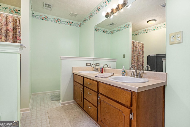 bathroom with visible vents, a sink, and a textured ceiling