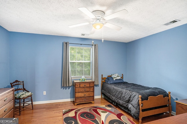 bedroom featuring a textured ceiling, wood finished floors, and visible vents