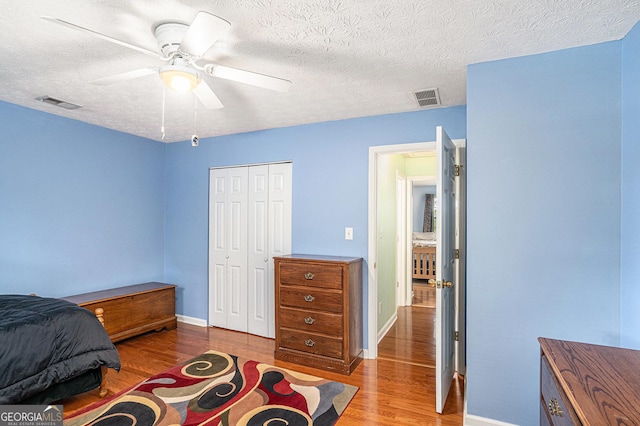 bedroom featuring visible vents, wood finished floors, and a closet