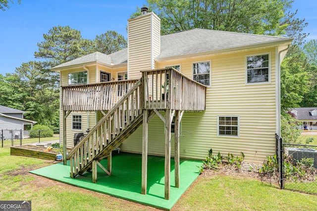 back of house with a wooden deck, fence, roof with shingles, a chimney, and stairs