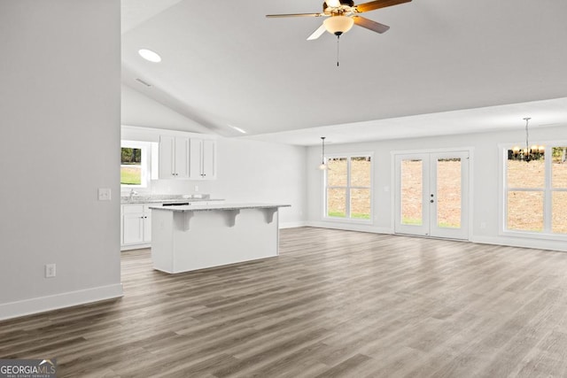 445 Liberty Hill Rd Unit 22, Hartwell, GA 30643 - unfurnished living room with ceiling fan with notable chandelier, vaulted ceiling, wood finished floors, and baseboards