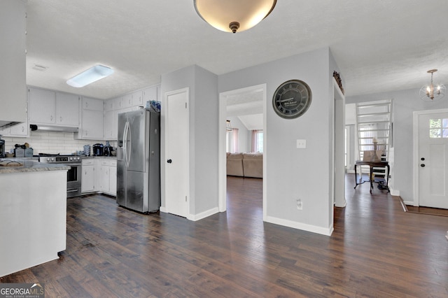 kitchen with appliances with stainless steel finishes, under cabinet range hood, healthy amount of natural light, and dark wood-type flooring