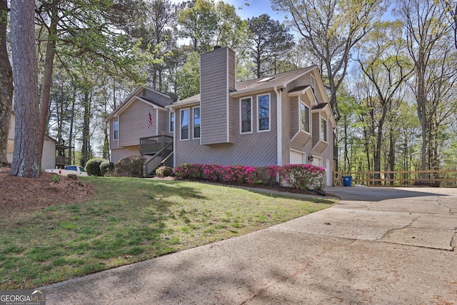 view of front facade featuring a chimney, concrete driveway, a garage, and stairs