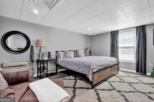 bedroom featuring baseboards and a drop ceiling