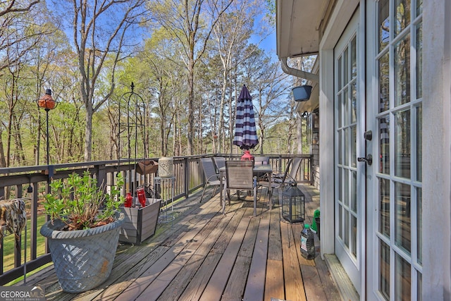 wooden deck featuring french doors and outdoor dining area