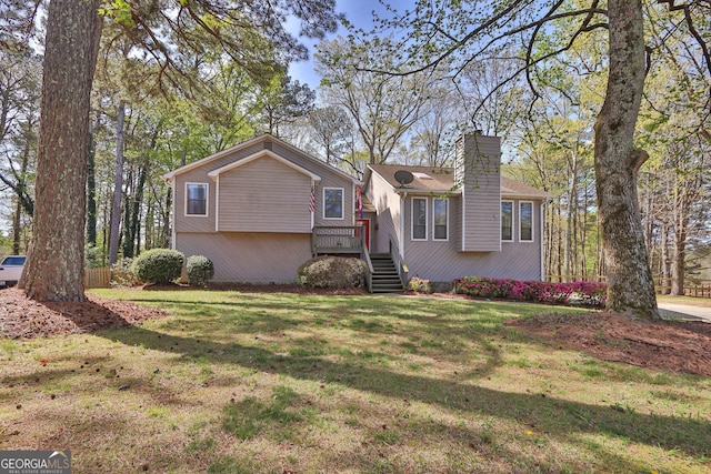 view of front of house with a chimney, a front lawn, and a deck