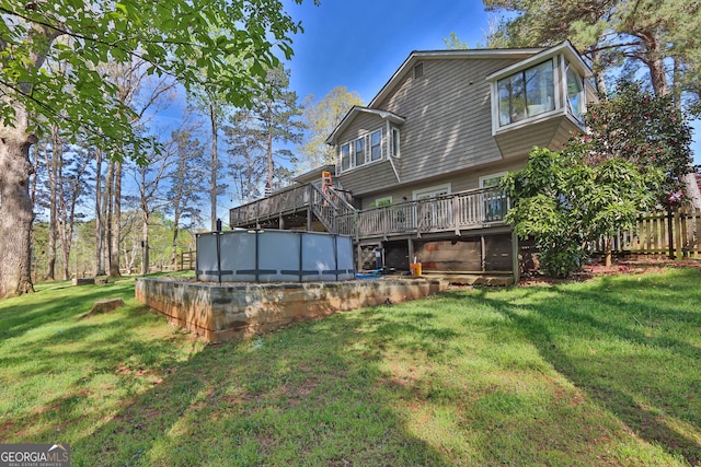 back of property with a deck and an outdoor pool