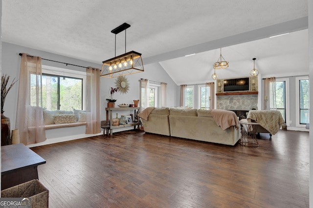 living room with a fireplace, dark wood-style flooring, lofted ceiling, a chandelier, and baseboards