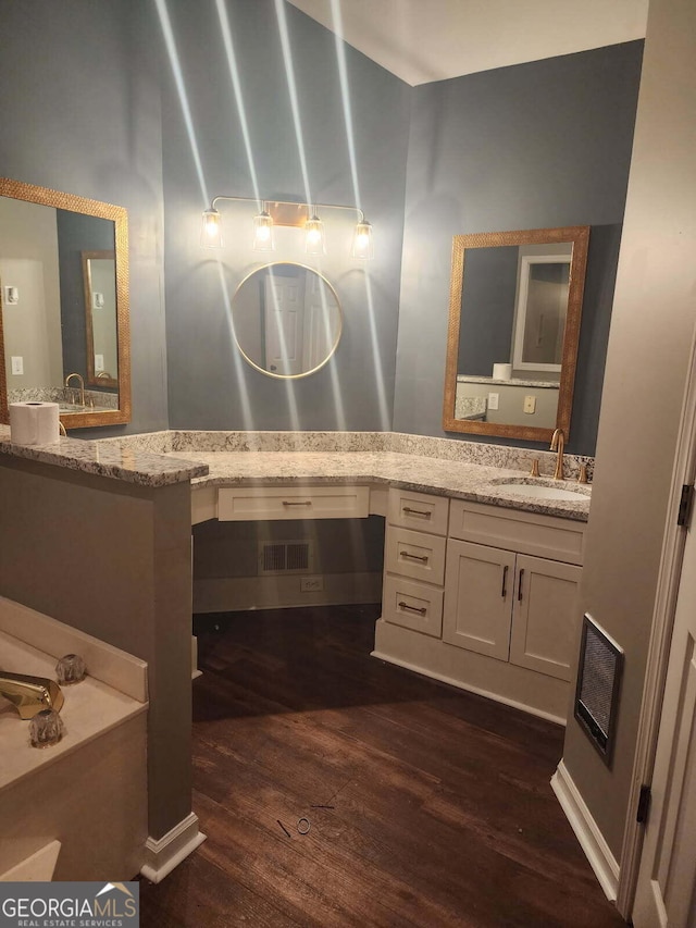 full bathroom featuring vanity, visible vents, and wood finished floors