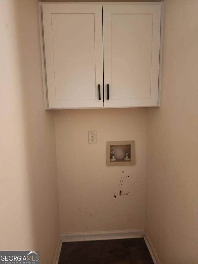 laundry room with cabinet space, washer hookup, and baseboards