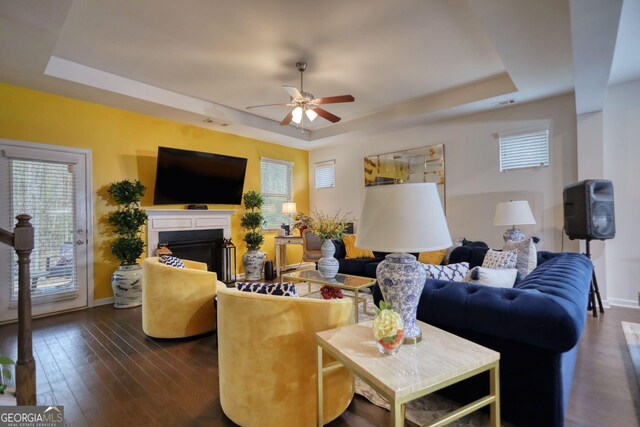 164 Madison Grace Ave, Mcdonough, GA 30252 - living room with a tray ceiling, a fireplace, baseboards, ceiling fan, and dark wood-type flooring