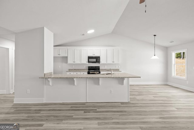 357 Liberty Hill Rd Unit 18, Hartwell, GA 30643 - kitchen with white cabinetry, a breakfast bar area, black appliances, and light stone counters