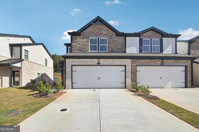 view of front of property featuring a front yard, concrete driveway, and a garage