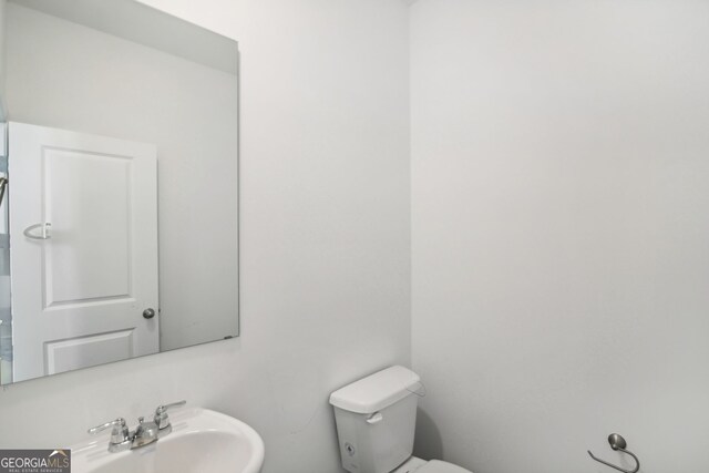 half bath featuring a sink and toilet
