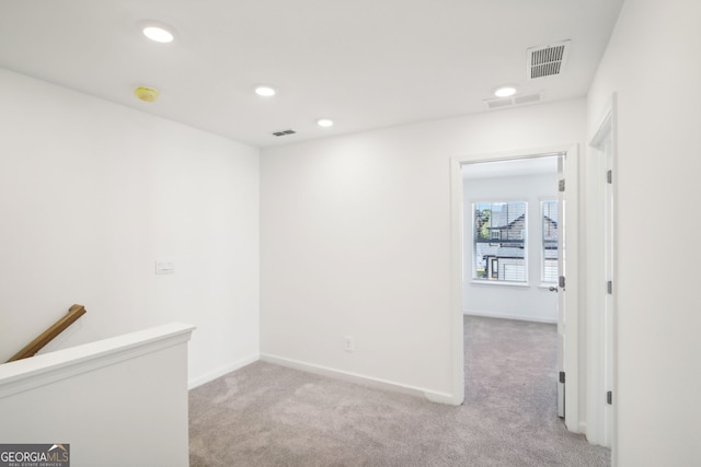 interior space featuring visible vents, an upstairs landing, and carpet