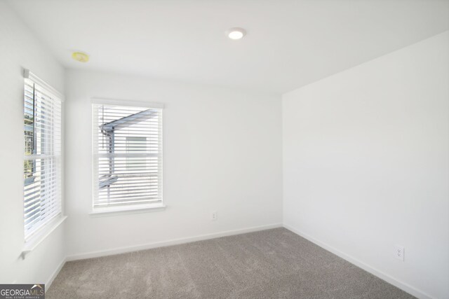 spare room with baseboards and carpet