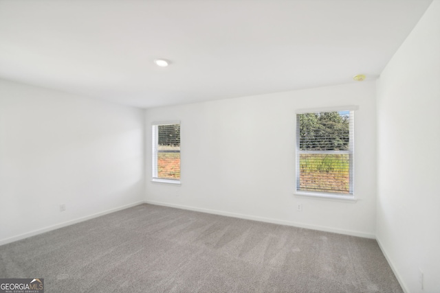 carpeted spare room featuring baseboards and recessed lighting