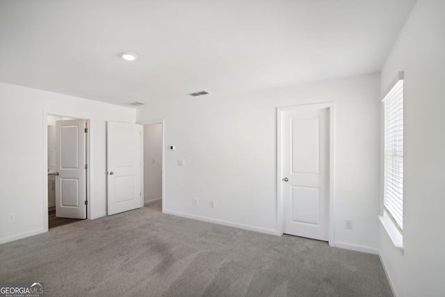 unfurnished bedroom with baseboards, visible vents, and carpet flooring